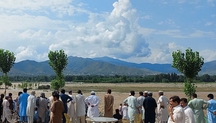 Residents gather, after tourists, who were on a picnic, were swept away by overflowing floodwaters in the Swat River on June 27, 2025. — Reuters